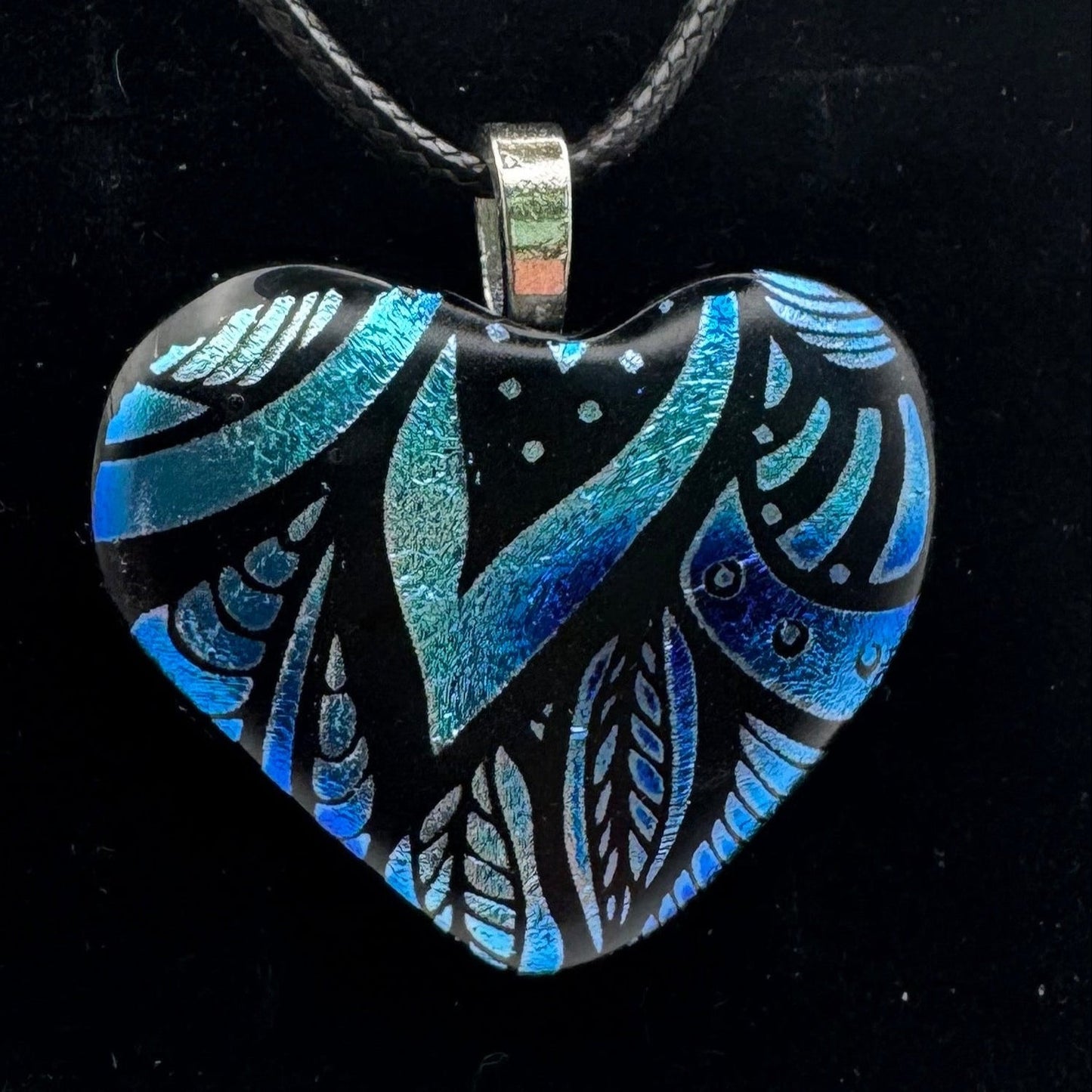 Heart-shaped pendant with blue and black design.